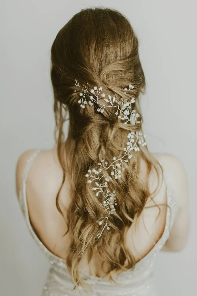 Peinado de novia semirrecogido con tocado de flores