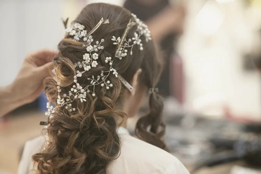 Estilista terminando un recogido de novia con flores