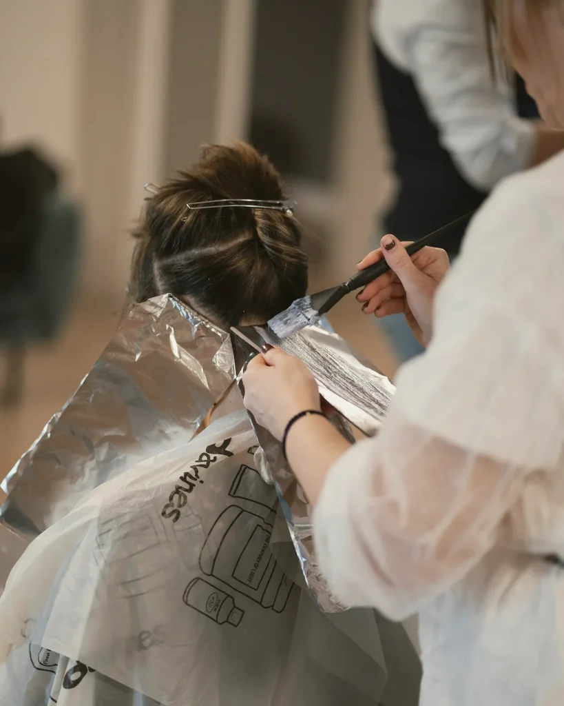 Estilista aplicando mechas con papel de aluminio